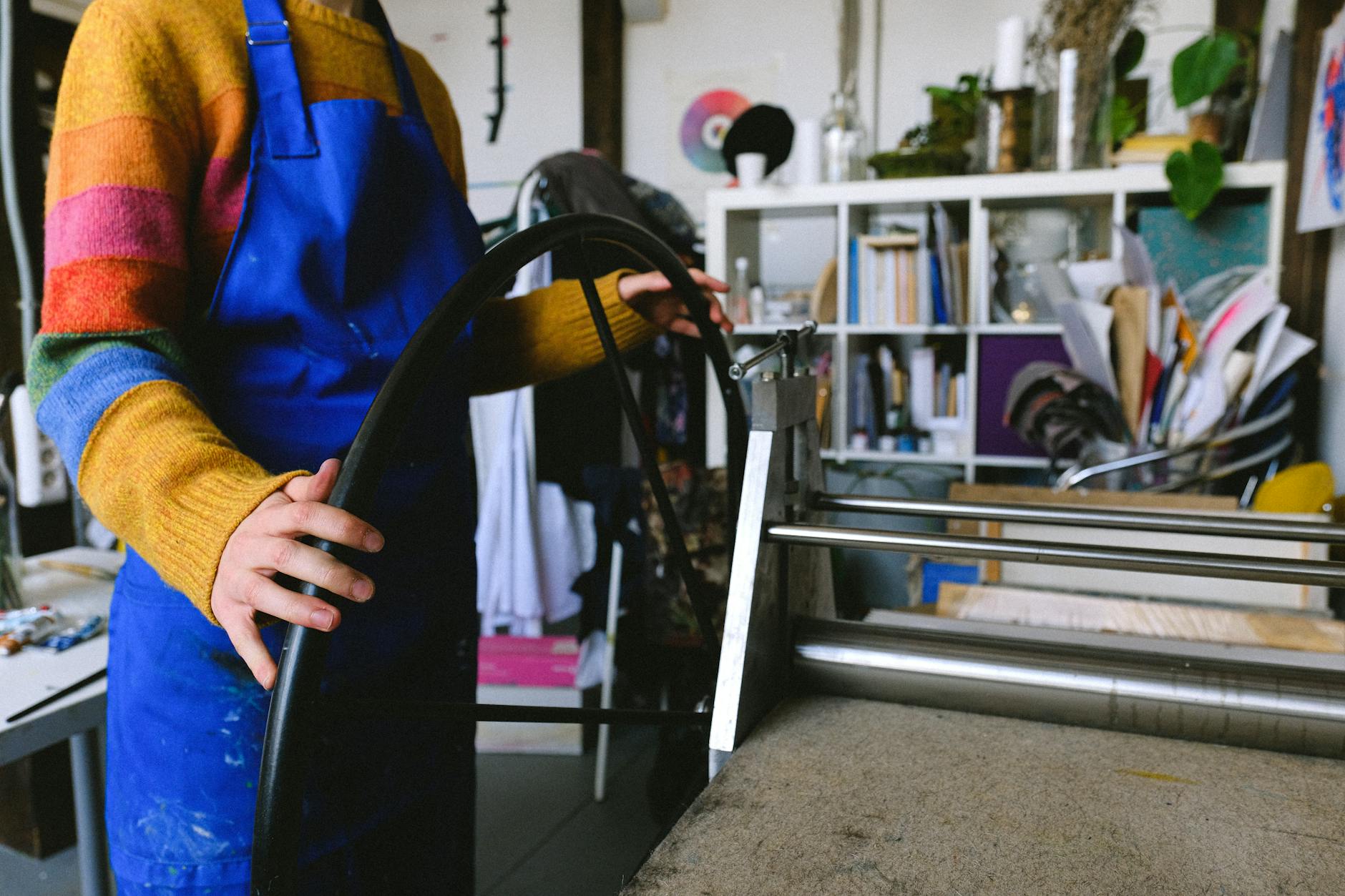 professional craftswoman working on printing machine in workshop