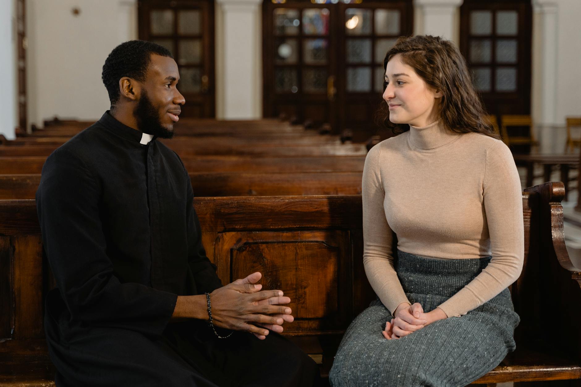 a woman and a priest talking