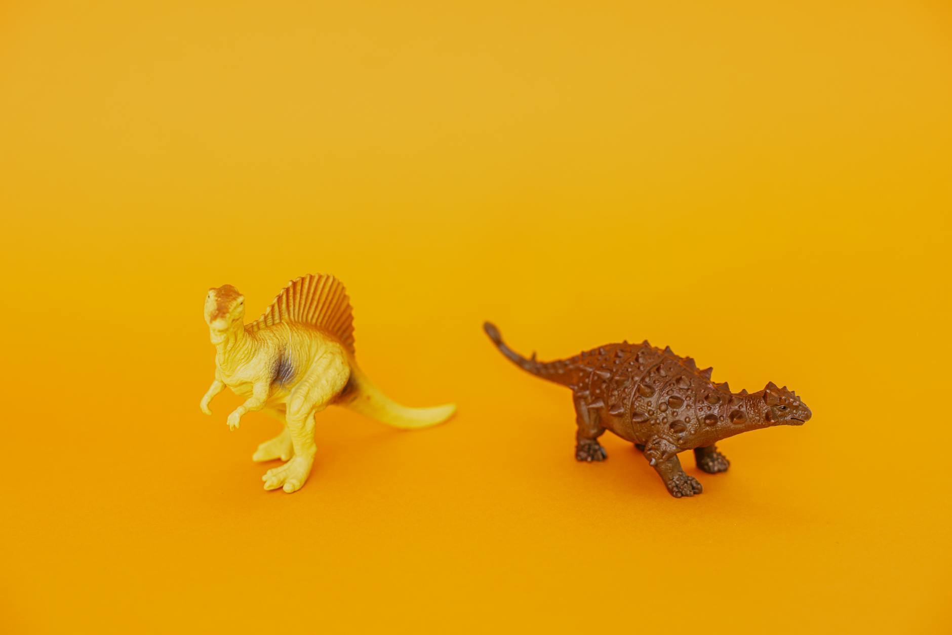 plastic dinosaur toys on yellow surface
