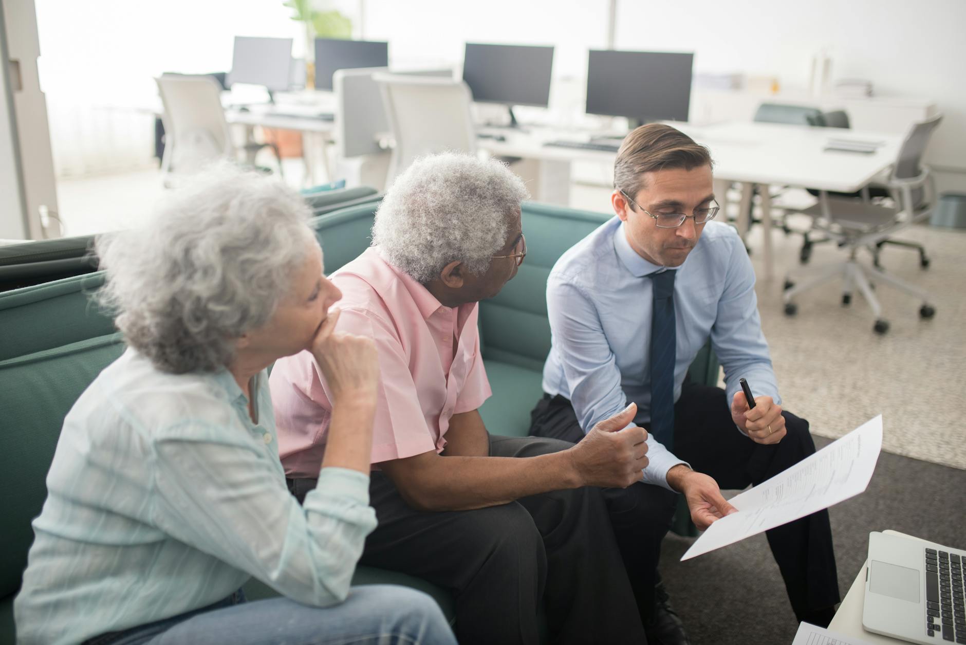elderly man and woman talking with insurance agent in office