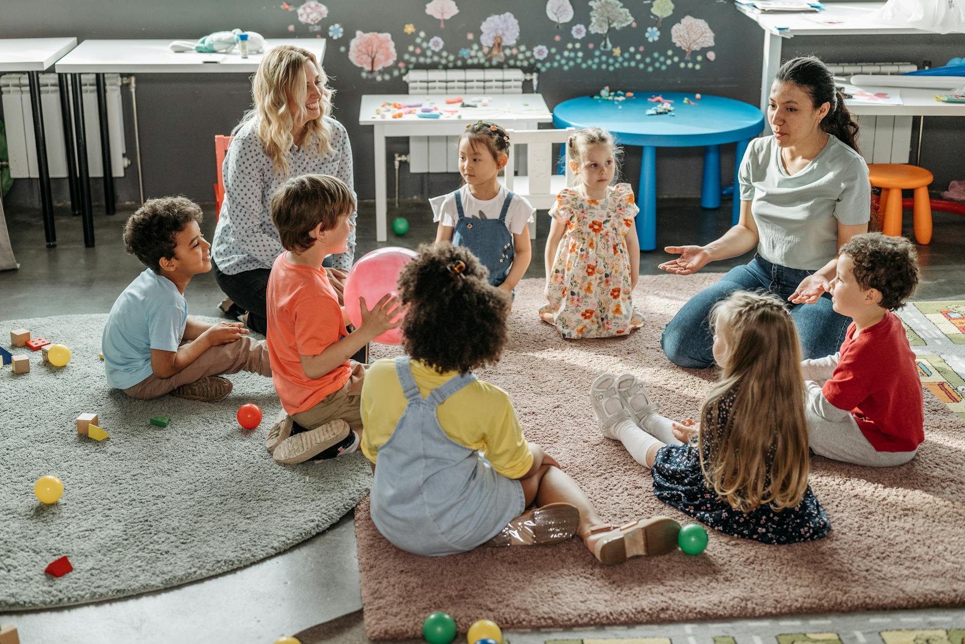 kids with their teacher sitting on the floor