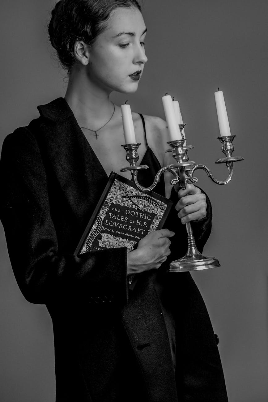attractive woman holding a book and candlestick, 10 Best Gothic and Romantic Literary Criticism