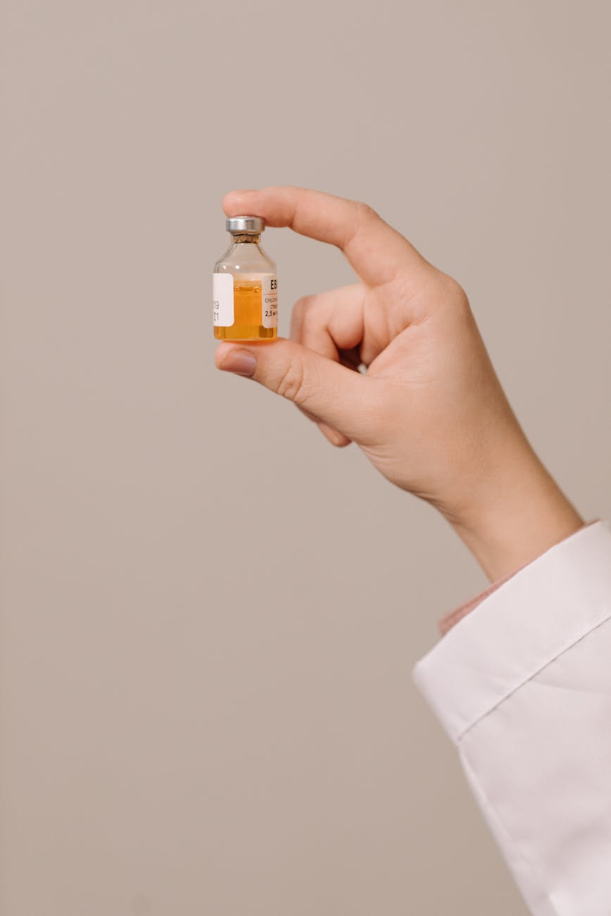 close up photo of a person holding a vaccine in a vial