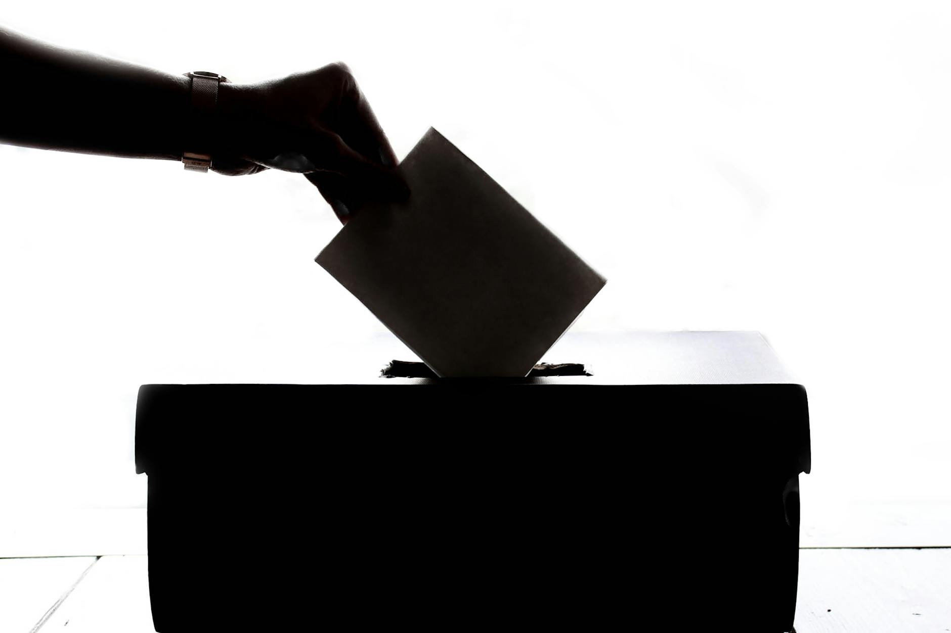 person dropping paper on box, General Elections and Political Process