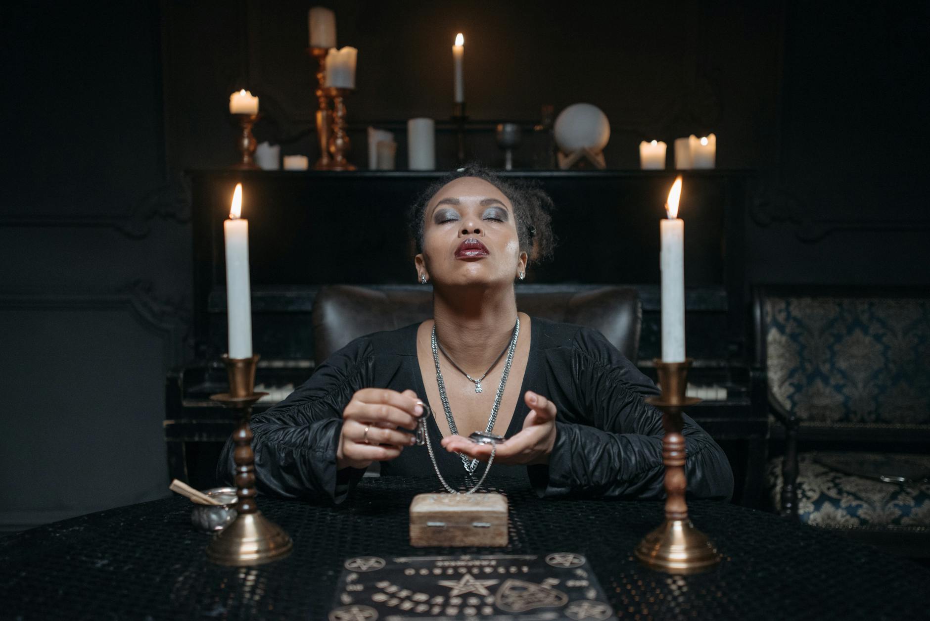 woman in black clothes sitting at the table with candles