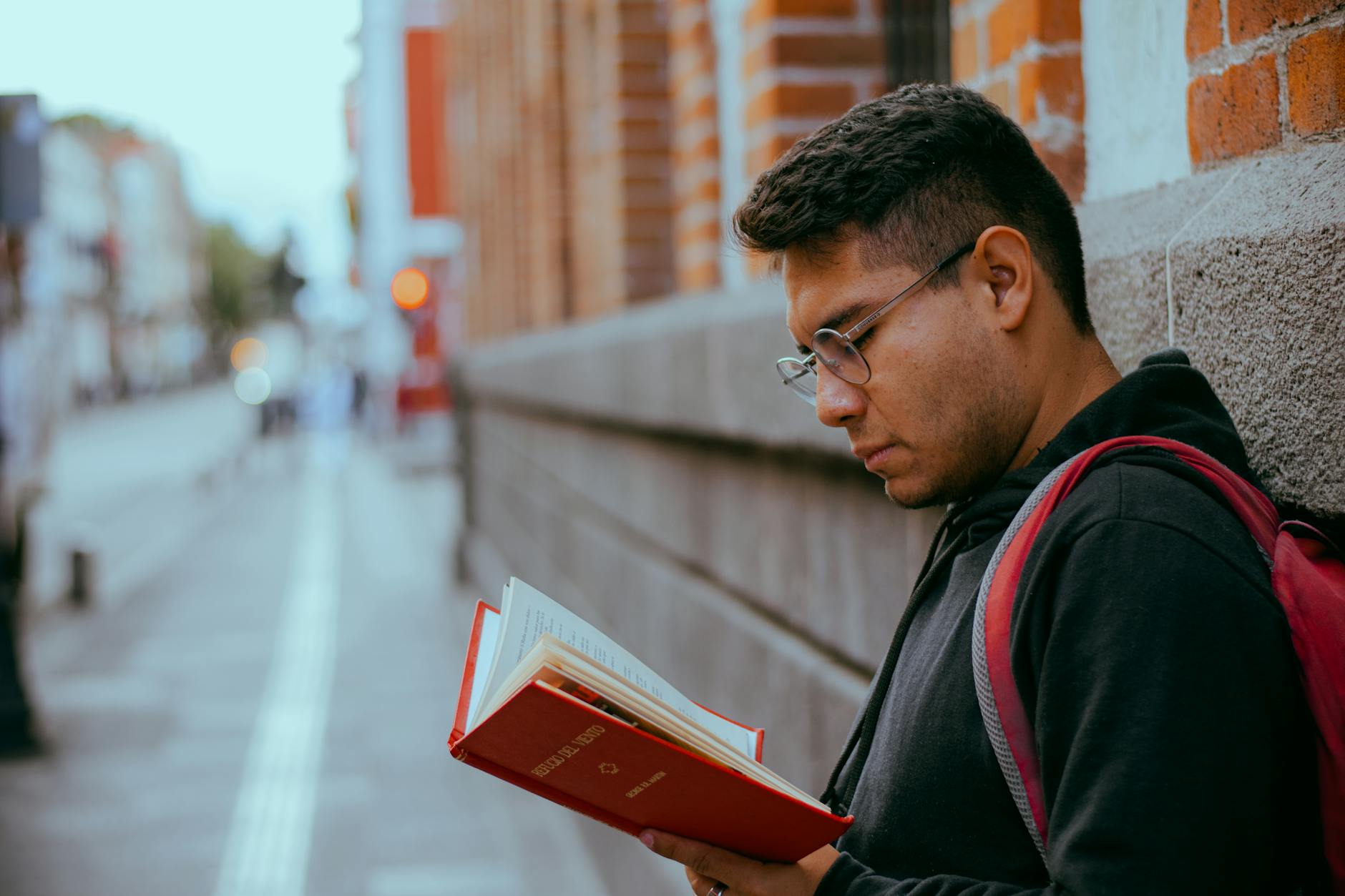 young man reading outdoors urban setting