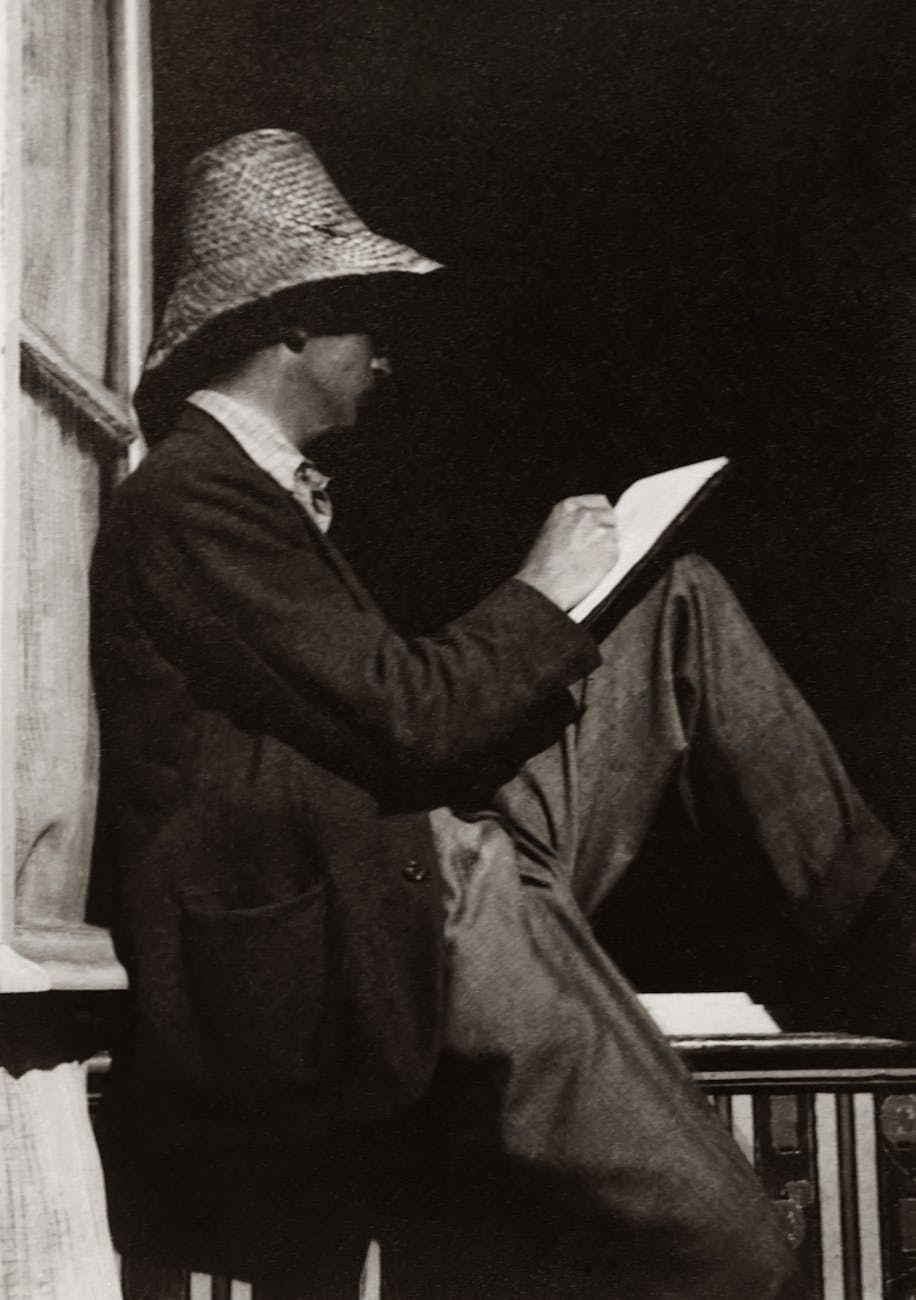 man writing on notebook while sitting on wooden handrail, Teen and Young Adult Artist Biographies