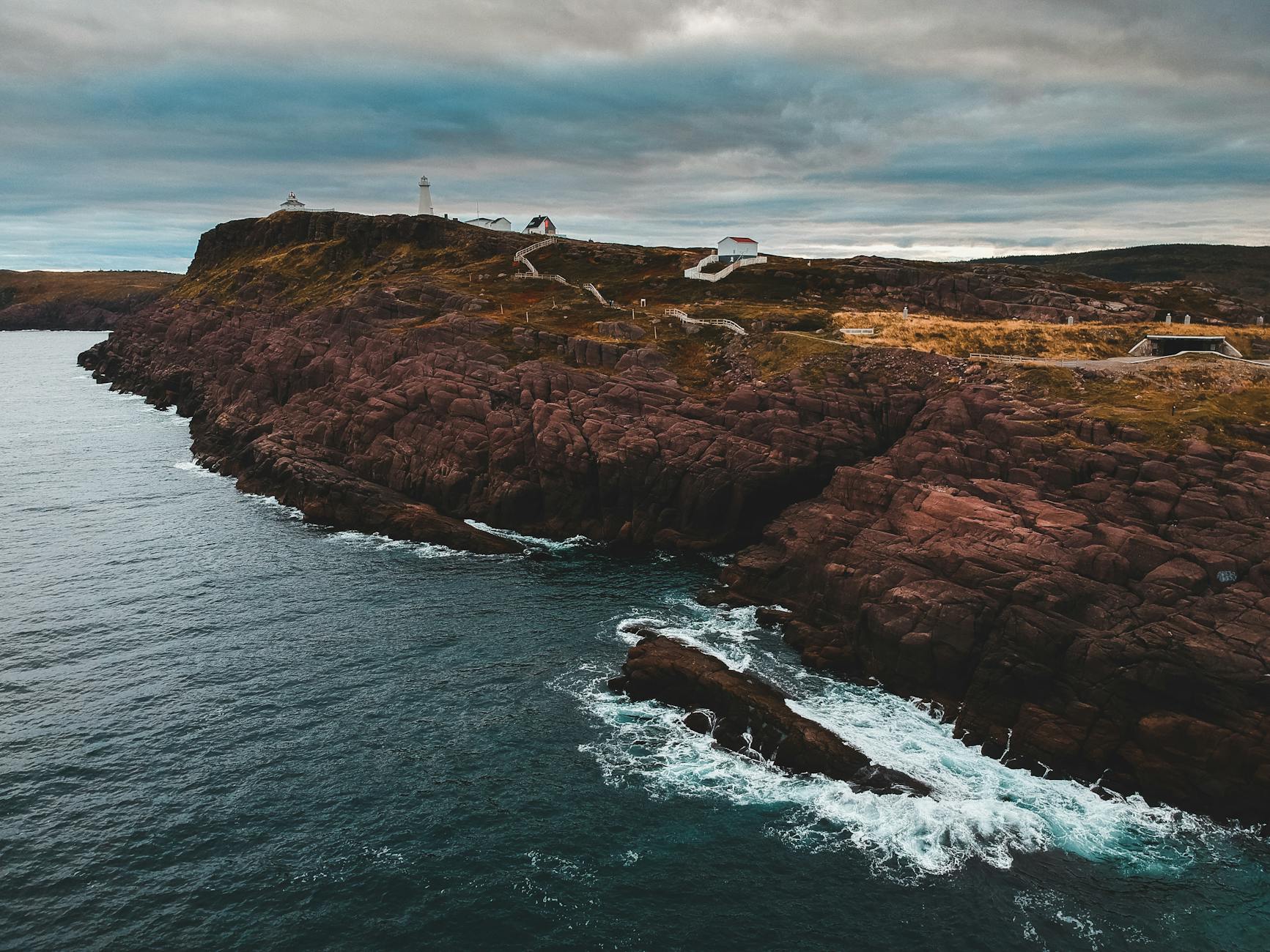 brown rock formation beside body of water