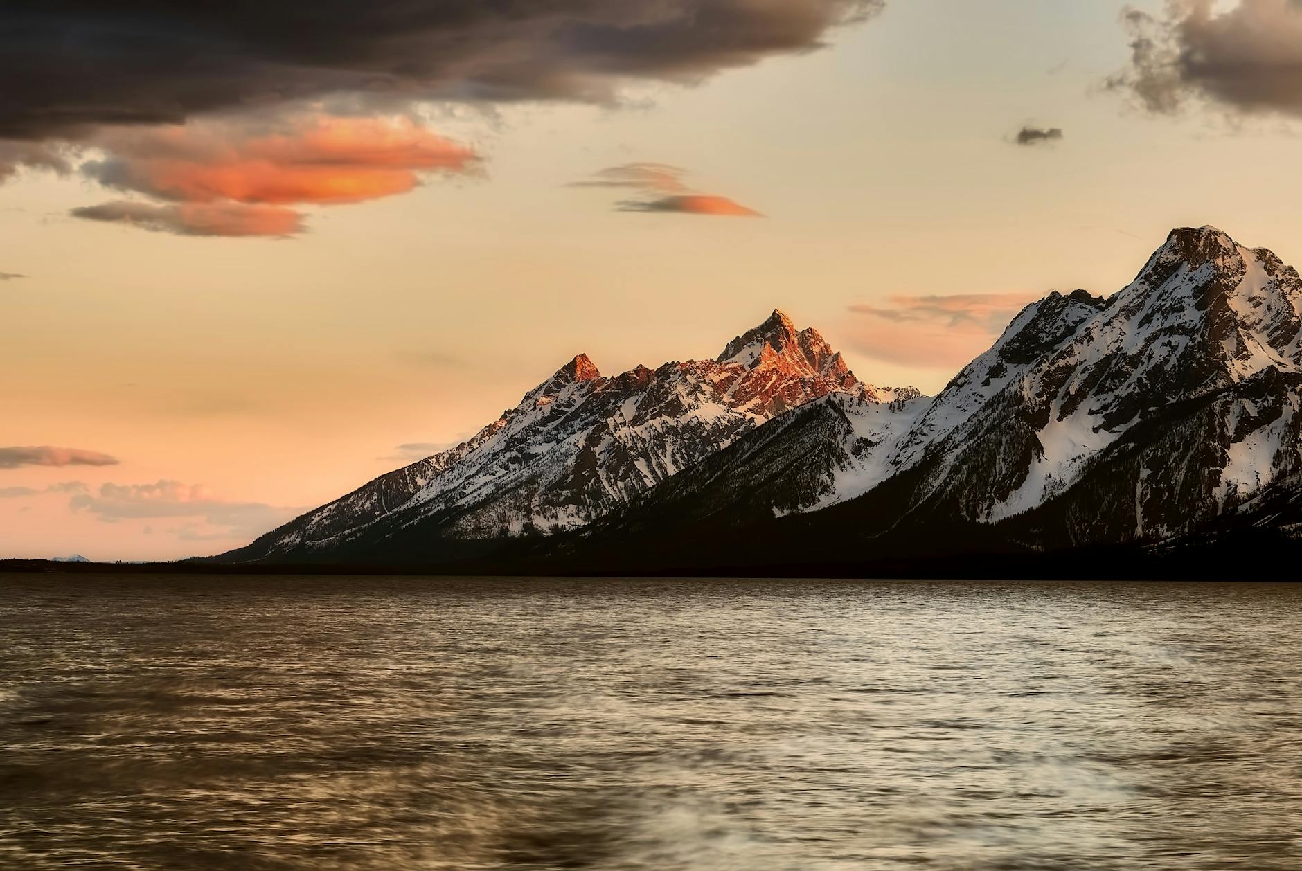 black mountain on body of water under sky