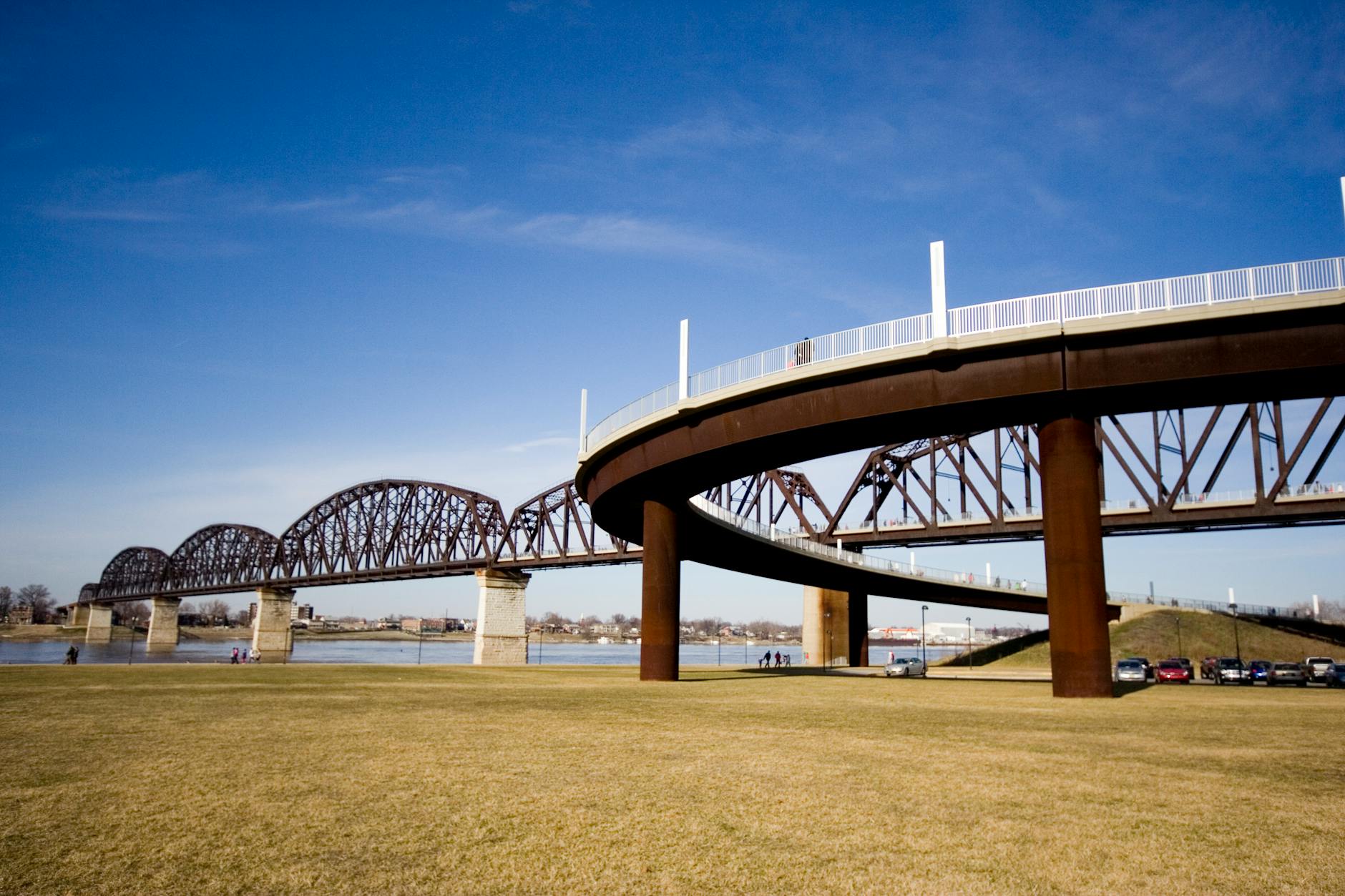 low angle photography of brown and gray bridge under blue calm sky