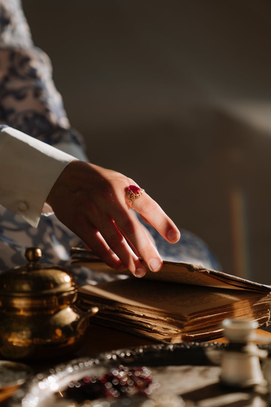 person in white long sleeve shirt holding brown wooden table, Book of Kells